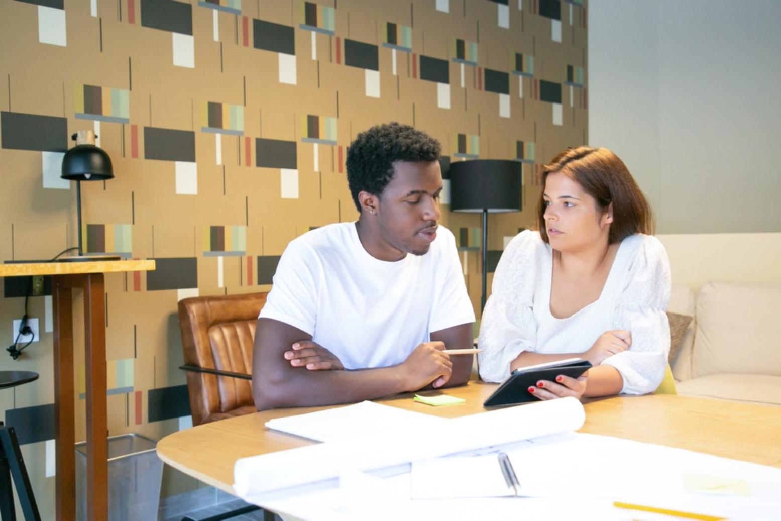 Estudiante internacional revisando presupuesto y documentos financieros en escritorio organizado